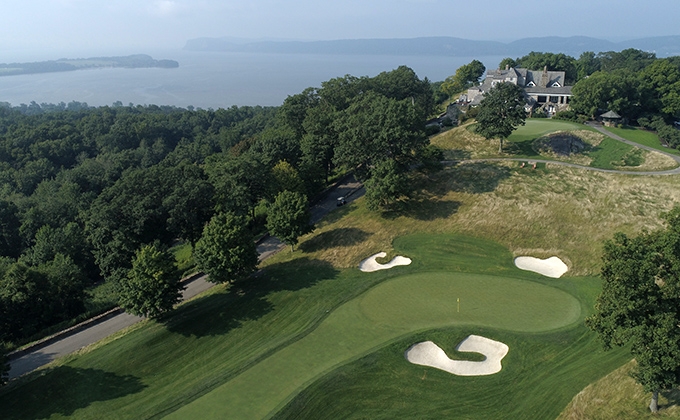 The 18th green and clubhouse at Hudson National Golf Club overlooking the Hudson River
