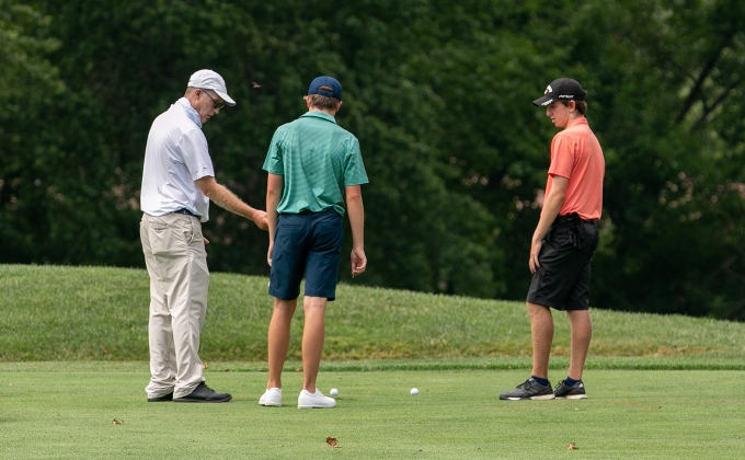 Rules official talking with two players