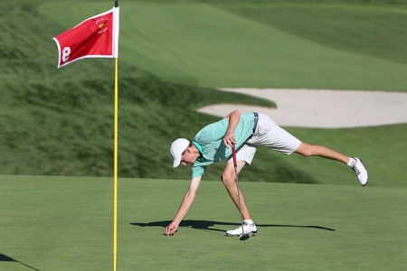 Golfer fixing a ball mark on putting green