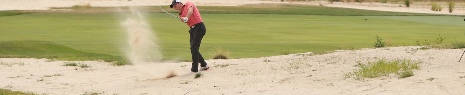 Golfer hitting out of sand trap